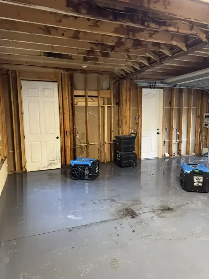 Dehumidifiers drying a gutted lower level after a water loss