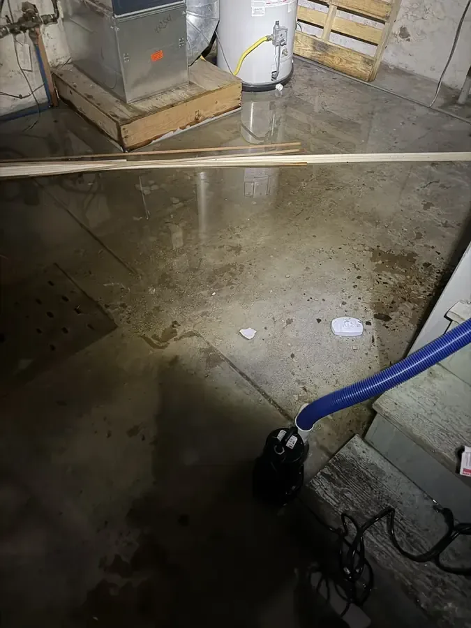 A corroded pipe leak traced at the base of a wall