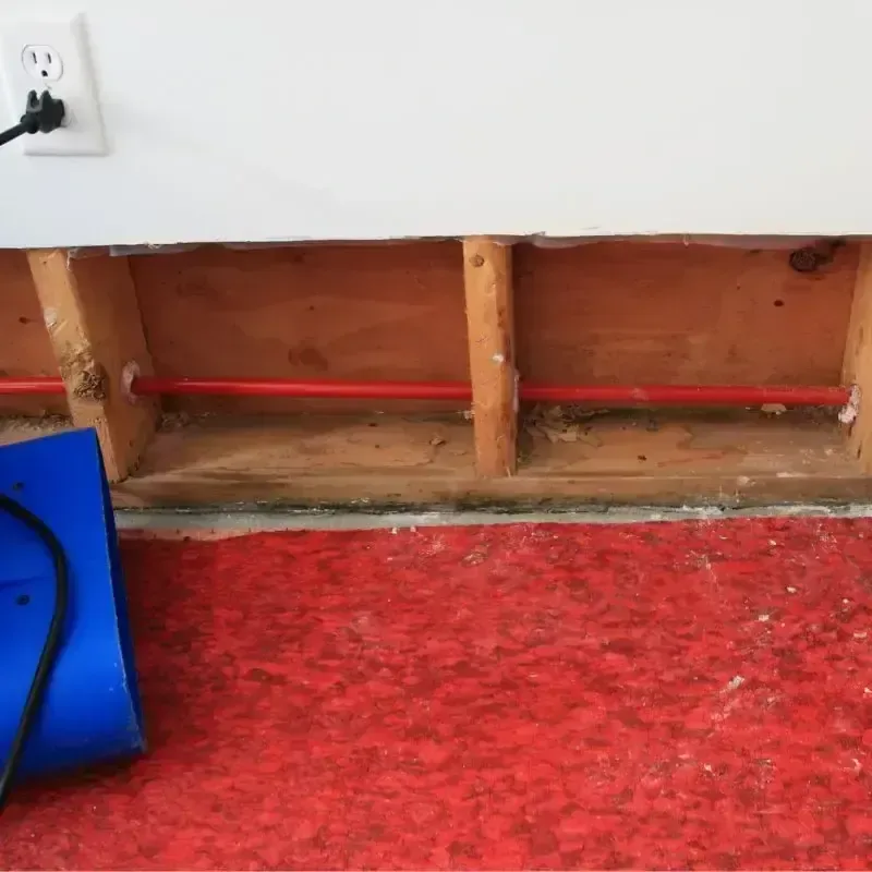 Water extraction wand pulling water from a garage floor