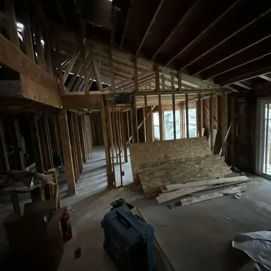 A room stripped back to bare wall and ceiling framing after water damage